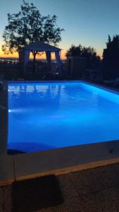 a blue swimming pool with a gazebo in the background at Vivienda Rural Villa Ruben in Jaén