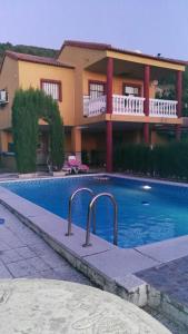 uma casa com piscina em frente a um edifício em Vivienda Rural Villa Ruben em Jaén