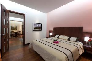 クエンカにあるGran Colombia Suitesのベッドルーム1室(花の咲く大型ベッド1台付)