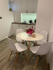 uma mesa branca e cadeiras numa cozinha em SOLE Apartment 1 em Satu Mare