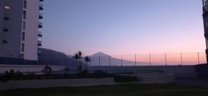 a view of a fence with a mountain in the background at Beautiful beach in Santa Cruz de Tenerife