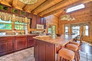 una cocina con armarios de madera y una gran isla con taburetes. en Stunning Vermont Cabin with Private Lake Access, en Poultney