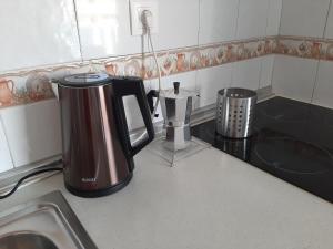 eine Kaffeemaschine auf der Küchentheke in der Unterkunft Perfectly located apartment with pool in Playa de las Americas