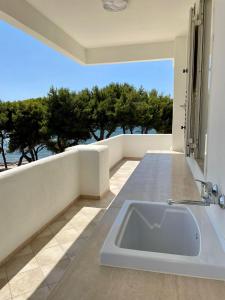 Attico Margherita - LA TERRAZZA SUL MARE في غالّيبولي: حمام مع حوض استحمام مطل على المحيط