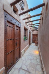 a walkway with a pair of doors on a house at Bait Alharah in Al Jināh