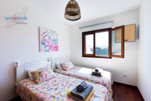 sypialnia z dwoma łóżkami i oknem w obiekcie Vivienda Vacacional Del Mar w mieście Playa Blanca +32 zdjęcia