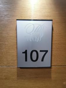 ein weißes Schild an einer Holztür mit der Nummer in der Unterkunft Apartman 107 - Aparthotel Vučko Jahorina - private host in Jahorina