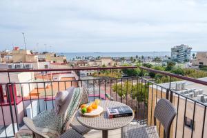 a balcony with a table and chairs and the ocean at Tgna Reial 1 in Tarragona