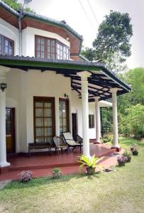 een huis met een houten patio met een dak bij Pearl House in Kandy