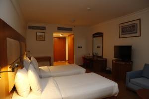 Ein Bett oder Betten in einem Zimmer der Unterkunft The Palace Hotel - فندق القصر