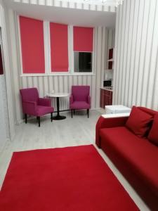 a living room with red furniture and a red rug at Apart Hotel Триумф Астаны 22 этаж, Секция 2 in Astana