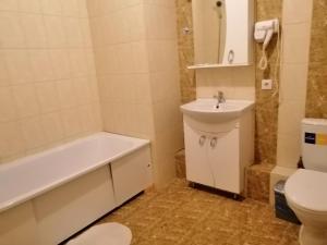 a bathroom with a sink and a tub and a toilet at Apart Hotel Триумф Астаны 22 этаж, Секция 2 in Astana