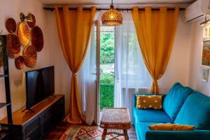 un soggiorno con divano blu e TV di Little Boho-Chic a Constanţa