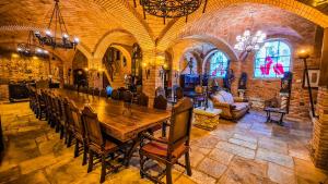 um quarto grande com uma grande mesa de madeira e cadeiras em Hotel Castelo Nacional Inn Campos do Jordão em Campos do Jordão