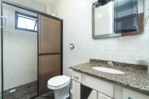 y baño con aseo, lavabo y ducha. en APARTAMENTO BEIRA MAR LATERAL NA PRAIA DE MARISCAL 2662 en Bombinhas