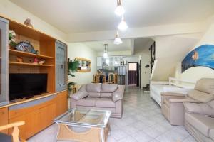 a living room with a couch and a tv at APARTAMENTO BEIRA MAR LATERAL NA PRAIA DE MARISCAL 2662 in Bombinhas