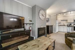a kitchen and a living room with a fireplace and a table at Whiffletree C2 in Killington