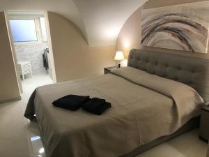 a bedroom with a bed with two black towels on it at Donizetti House in Catania