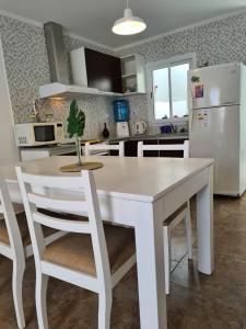 een keuken met een witte tafel en een witte koelkast bij Apart 14 de Julio in Tandil