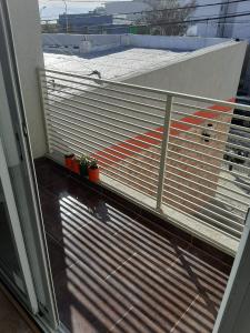 een balkon met een metalen hek en potplanten bij Apart 14 de Julio in Tandil