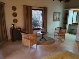 a living room with chairs and a table and a window at Somkhanda Game Reserve in Pongola