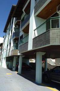 un edificio con un coche aparcado delante de él en Centrinho Canasvieiras 202 2 andar, en Florianópolis