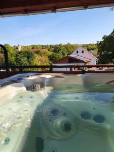 a jacuzzi tub with a view of a house at Buzás Pince Vendégház in Ecséd