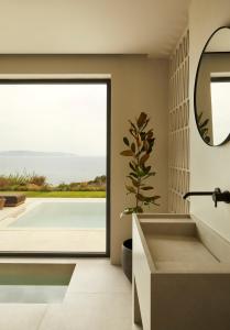 a bathroom with a large window and a sink and a mirror at Villa Dione Kefalonian Chic Villas in Spartia