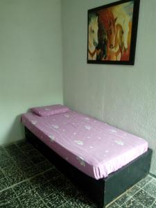 a small bed in a room with a picture on the wall at CASA CUCHILLA ALTA in Cuchilla Alta