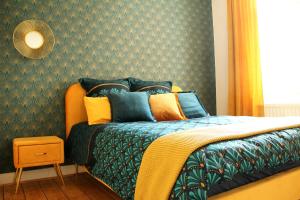 1 dormitorio con 1 cama con almohadas verdes y amarillas en SECRET HIDEAWAYS zentrales NewYork-Designapartment mit 2 Betten nahe Messe l Flughafen, en Duisburg