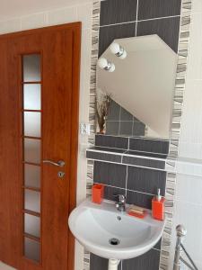 a bathroom with a sink and a mirror at Podkrovný Apartmán Attic 32 Telgárt in Telgárt +12 photos