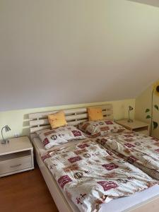 a bedroom with two beds and two night stands at Podkrovný Apartmán Attic 32 Telgárt in Telgárt