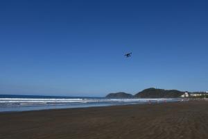 Eine Gruppe von Menschen am Strand, die einen Drachen fliegen in der Unterkunft 12B Jaco Sol Quadplex in Jacó