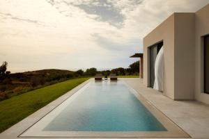 a swimming pool in the backyard of a house at Villa Dione Kefalonian Chic Villas in Spartià