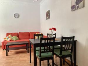 uma sala de estar com uma mesa e um sofá vermelho em Apartamento RETECH em Las Palmas de Gran Canaria