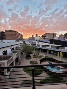 uma vista para uma cidade com edifícios e um pôr-do-sol em Trendy apartment @ maboneng em Joanesburgo