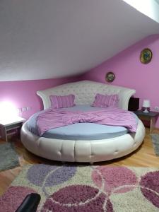 een slaapkamer met een wit bed en een paarse muur bij Durmitor in Kumanovo