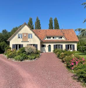 una casa con techo rojo y entrada de grava en Le Vrai Paradis, en Estréboeuf