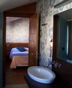a bathroom with a sink and a bedroom with a bed at Posada Real Los Cinco Linajes in Arévalo