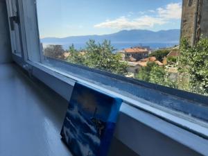 a book sitting on a window sill with a view at Amarena Apartment in Rijeka