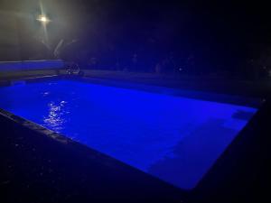 a blue swimming pool at night with a light at L'escapade créole Jacuzzi Privatif Bungalow Vanille in Saint-Joseph