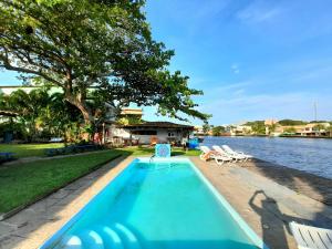 カボ・フリオにあるDe Boa na Lagoa Cabo Frioの水の隣のスイミングプール