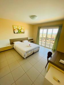 um quarto de hotel com uma cama e uma grande janela em Villa San Valentino em Aquiraz