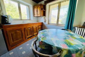 eine Küche mit einem Tisch, einem Waschbecken und Fenstern in der Unterkunft Nice Chalet With View On The Mountain in La Salle Les Alpes