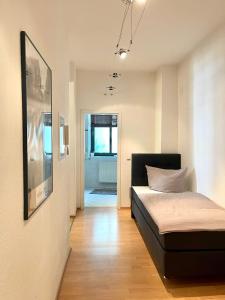 a small bedroom with a bed and a hallway at City Center Leipzig II in Leipzig
