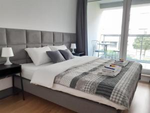 sypialnia z dużym łóżkiem i dużym oknem w obiekcie Vista Residence Spire w Warszawie