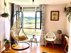 a living room with a chair and a window at Apartamento con vistas espectaculares al rio Sella in Ribadesella