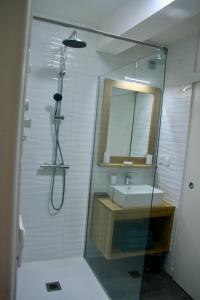 uma casa de banho com um chuveiro, um lavatório e um espelho. em Appartement T2 centre historique de Morlaix em Morlaix