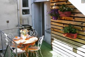 une table et des chaises sur un balcon avec une table et des fleurs dans l'établissement Appartement T2 centre historique de Morlaix, à Morlaix