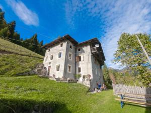 a building on top of a grassy hill at Casa Soraya in Falcade